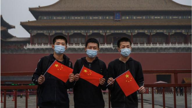 Jóvenes con mascarillas y banderas de China