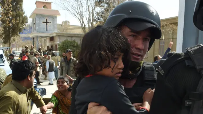 A young girl is carried away from the church by security personnel after the attaci in Quetta (December 17 2017)