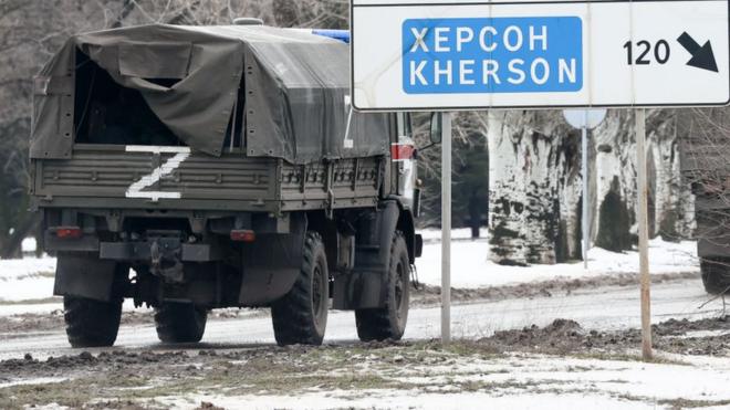 Russian military vehicle with Kherson road sign