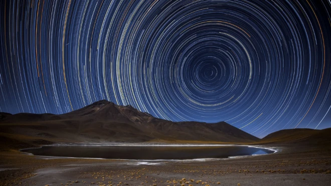 ภาพถ่ายท้องฟ้ายามค่ำคืนเหนือทะเลทรายอาตากามา แสงดาวที่ปรากฏเป็นเส้นยาวเกิดจากการหมุนของโลก