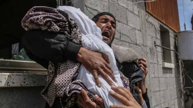 Seorang warga Palestina menggendong jenazah bayi perempuan berusia 14 bulan yang terpapar serangan roket Israel di sebelah timur Kota Gaza, Minggu (5/5).