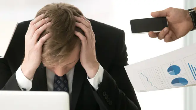 Офисный работник закрыл голову руками