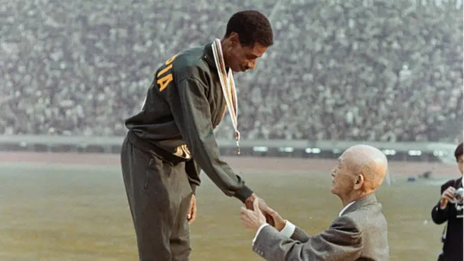 Abbabaa Biqilaan Olompikii Tookiyootti yeroo lammataaf maaraatonii mo'atee medaaliyaa fudhatu