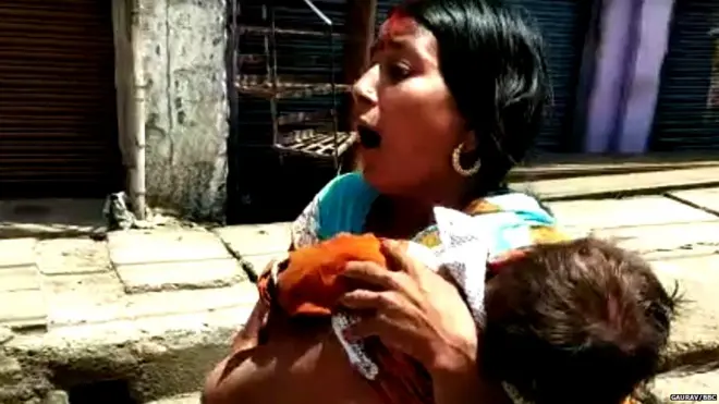 बच्चे की लाश लिए दौड़ती महिला