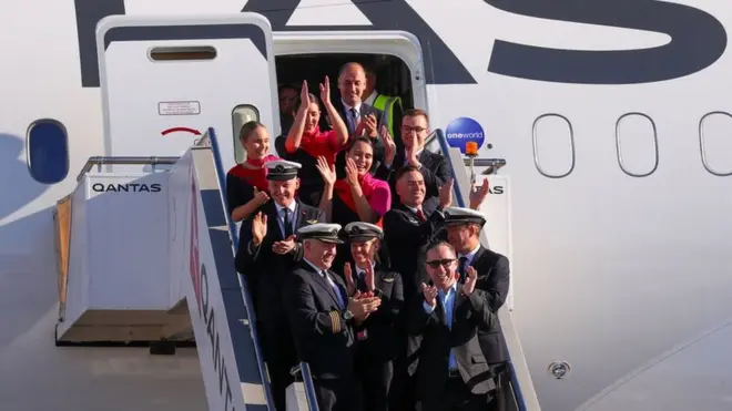 All smiles: Qantas crew celebrate after the 19-hour journey from New York to Sydney