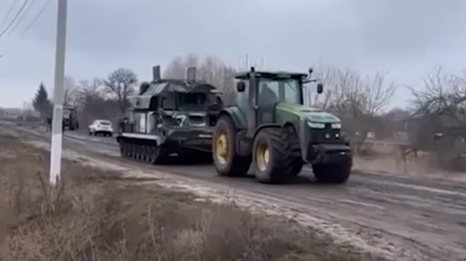 Ảnh chụp màn hình nông dân Ukraine dùng máy kéo kéo chiếc xe tăng của Nga được cho là hỏng hoặc hết nhiên liệu bị bỏ lại