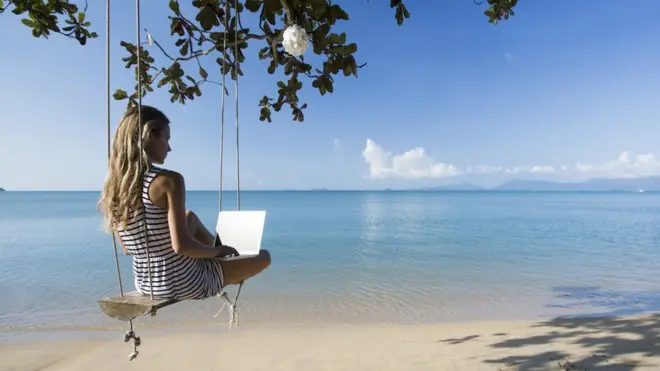 uzaktan çalışma, plaj kenarından çalışan bir kadın