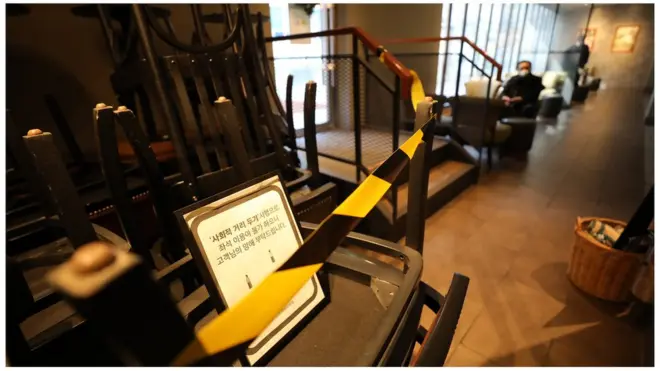 정부의 사회적 거리두기 2단계 시행을 하루 앞둔 23일 서울의 한 카페 한켠에 의자와 테이블이 쌓여 있다