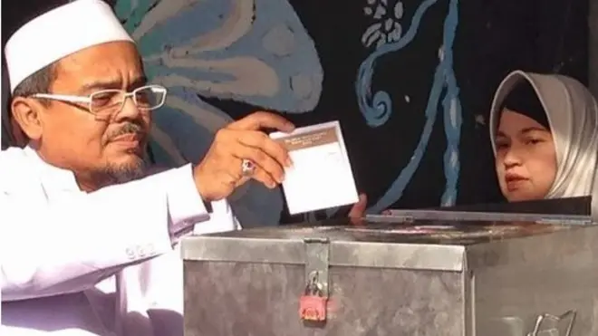 Rizieq Shihab mencoblos bersama isterinya.