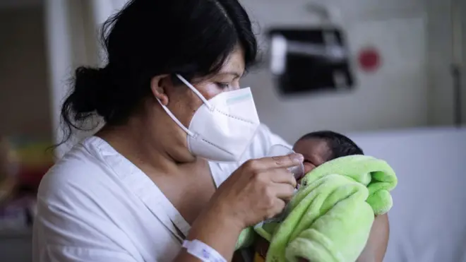 Женщина кормит грудничка