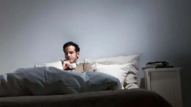 침대 위에서 일하는 남성