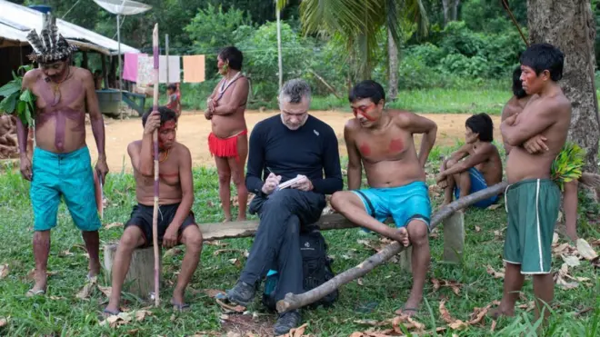 Dom Phillips taking notes as he talks to indigenous people at Aldeia Maloca Papiú, Roraima State, Brazil in 2019