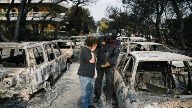 امرأة تبحث عن كلبها في قرية ماتي التي تقع في وسط الحرائق