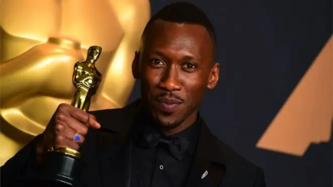 Mahershala Ali holding an Oscar