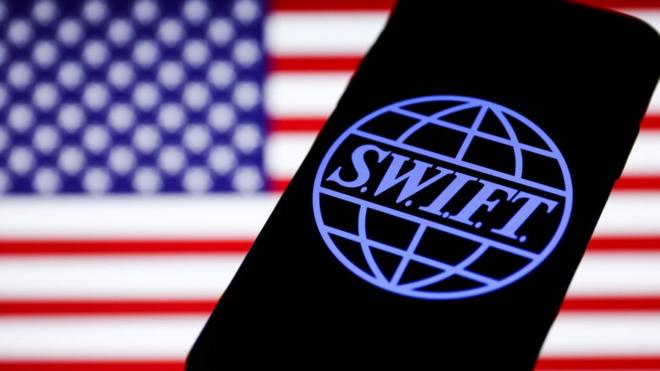 Logotipo SWIFT exibido na tela do telefone e bandeira americana exibida7games aplicativo para baixar apksegundo plano