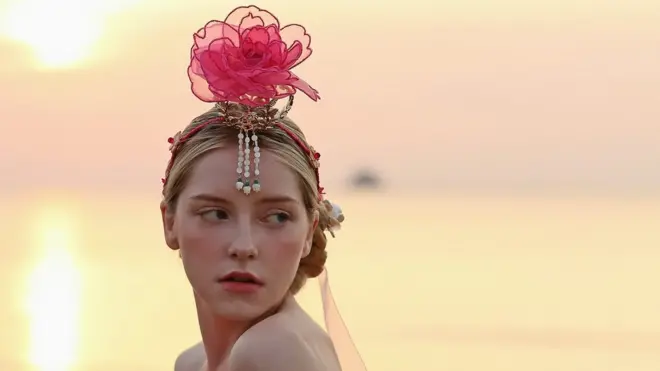 오간자 장미 황동 족두리를 쓴 모델이 포즈를 취하고 있다