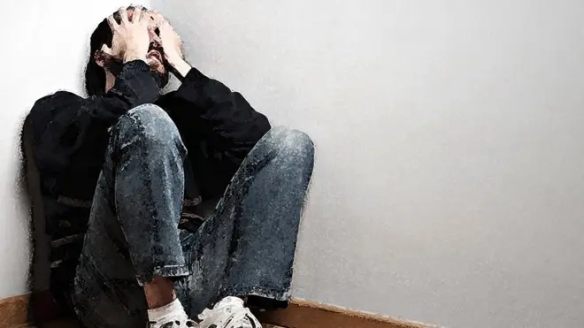 Illustration from a photo of a man sitting in the corner of a room holding his face