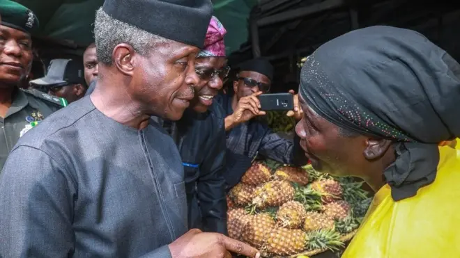 Nigeria Vice president Yemi Osinbajo dey tok to one of di market women wey benefit from Trader Moni for Lagos