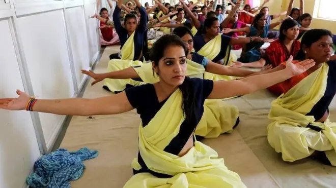 યોગ કરતી મહિલાઓની તસવીર