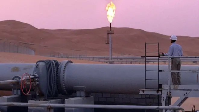 ایک ورکر پائپ لائن سے نکلنے والا شعلہ دیکھ رہا ہے