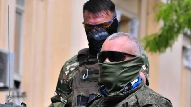 Two Wagner soldiers with their faces covered by masks