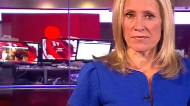 在这次新闻直播中，主播背后坐着的一名员工的电脑屏幕上出现了一名坦胸露乳的女子。