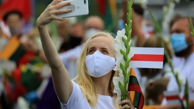 Девушка с телефоном и бело-красным флагом