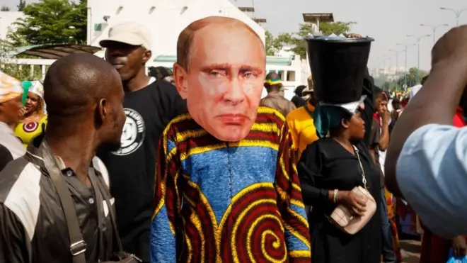 Un partisan du président intérimaire malien porte un masque facial du président de la Russie, Vladimir Poutine, lors d'un rassemblement pro-Junta et pro-Russie à Bamako, le 13 mai 2022.