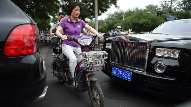 Rolls-Royce и скутер на дороге в Пекине