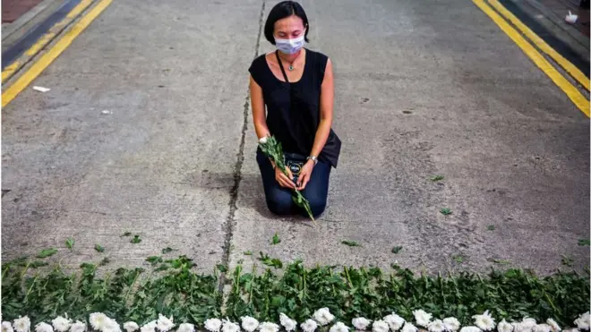 한 예술가가 도로에 꽃을 놓고 있다