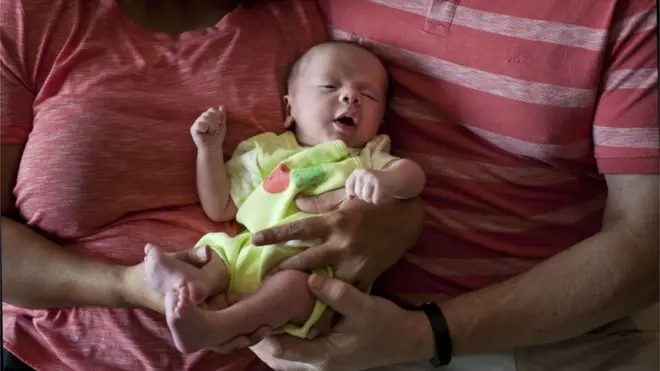 n this Nov. 5, 2015 file photo, a couple from Britain hold their baby, born on Oct. 17 by a surrogate, in Anand, India