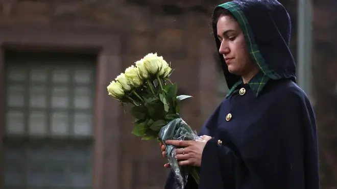 A Warden of the Palace of Holyroodhouse holds flowers