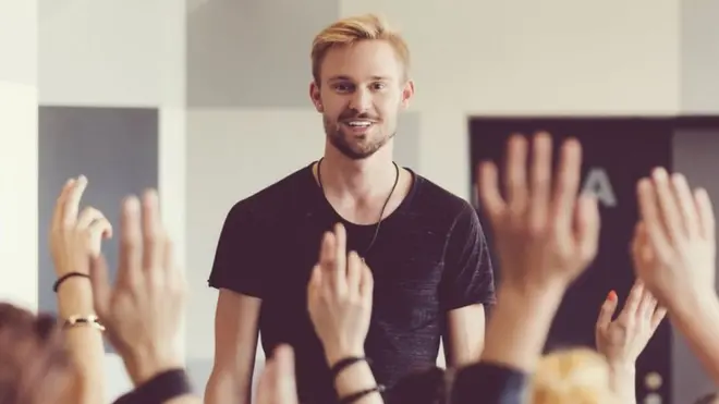 gente levantando la mano en una presentación