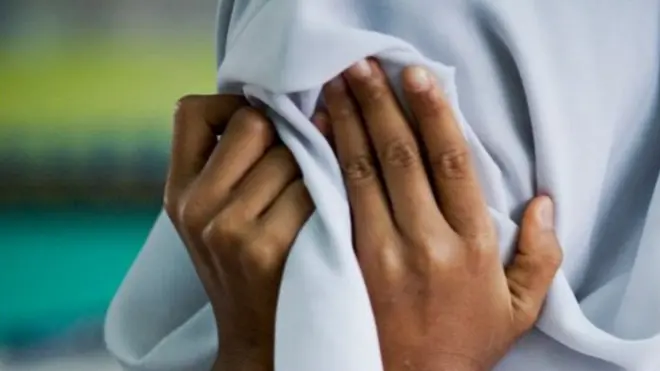 فتاة تضع يدها على وجهها