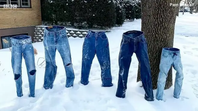 กางเกงยีนส์ตั้งอยู่บนหิมะกลางแจ้ง