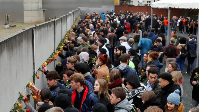People place roses at the Wall memorial during a ceremony marking the 30th anniversary of the fall of the Berlin Wall at Bernauer Strasse in Berlin, Germany November 9, 2019