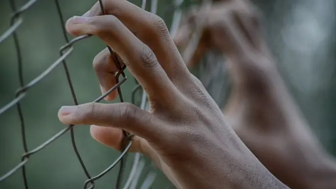 Hand dey hold prison fence