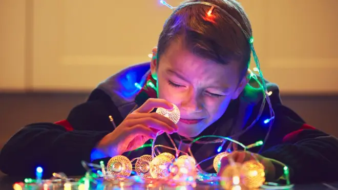 Niño con luces de Navidad