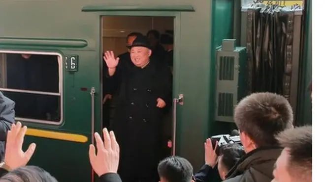 North Korean leader Kim Jong Un waves from a train in Beijing