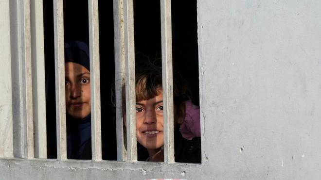 لاجئون سوريون ينظرون من نافذة إلى مخيم غير رسمي خلال شهر رمضان المبارك في المرج البقاع في لبنان، أبريل نيسان 2023.