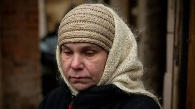 इरयाना अब्रामोव बूचा में अपने घर के बाहर खड़ी हैं. यहीं उनके पति को रूसी सैनिकों ने गोली मार दी थी.