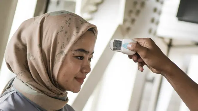 Petugas memeriksa suhu tubuh calon penumpang LRT (Light Rail Transit) di Stasiun LRT Velodrome, Jakarta, Selasa (3/3). Pemeriksaan suhu tubuh penumpang tersebut merupakan upaya untuk mengantisipasi penyebaran virus corona atau Covid-19.