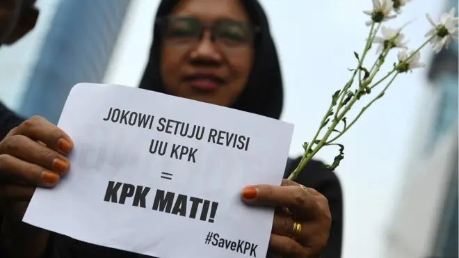 Pegawai KPK membawa bunga dan poster untuk dibagikan kepada warga pada melakukan aksi saat Hari Bebas Kendaraan Bermotor di kawasan Bundaran HI Jakarta, Minggu (8/9).