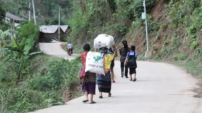 ชาวบ้านแม่สามแลบขนข้าวสารอาหารแห้งที่มีผู้นำมาแจกกลับเข้าหมู่บ้าน