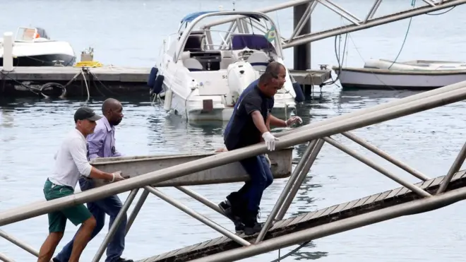Rescatistas llevan el cuerpo de una víctima a un barco de la Marina de Brasil.