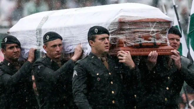 A coffin of a victim of the Chapecoense plane crash being carried into the stadium by the Brazilian military