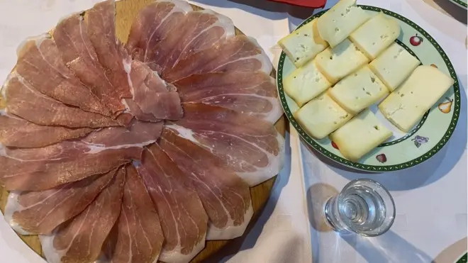 Pršuta se tradicionalno servira sa njeguškim sirom i crnogorskom lozom