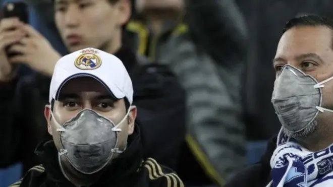 مشجعون يرتدون الأقنعة لمتابعة مباريات فريقهم