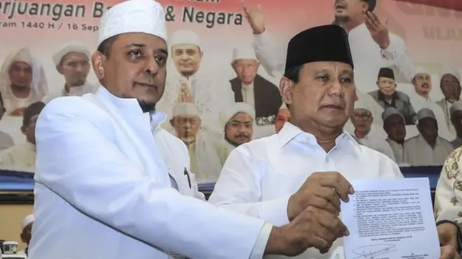 Ketua GNPF Ulama Yusuf Muhammad Martak dan Prabowo Subianto memperlihatkan pakta integritas yang disepekati kedua belah pihak pada Minggu (16/09).