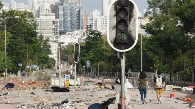 示威者把砖头等杂物扔到路上，令车辆无法驶过，同时破坏交通灯。